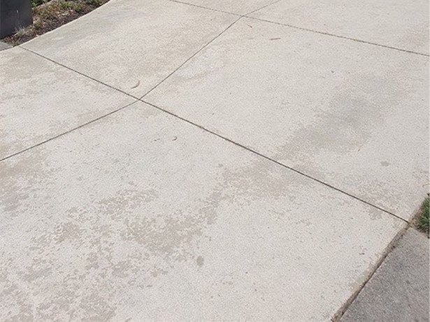 The same driveway washed back to pale, even concrete