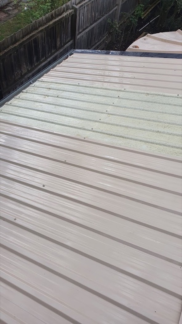Beige roof sheeting half cleaned, showing the difference in colour