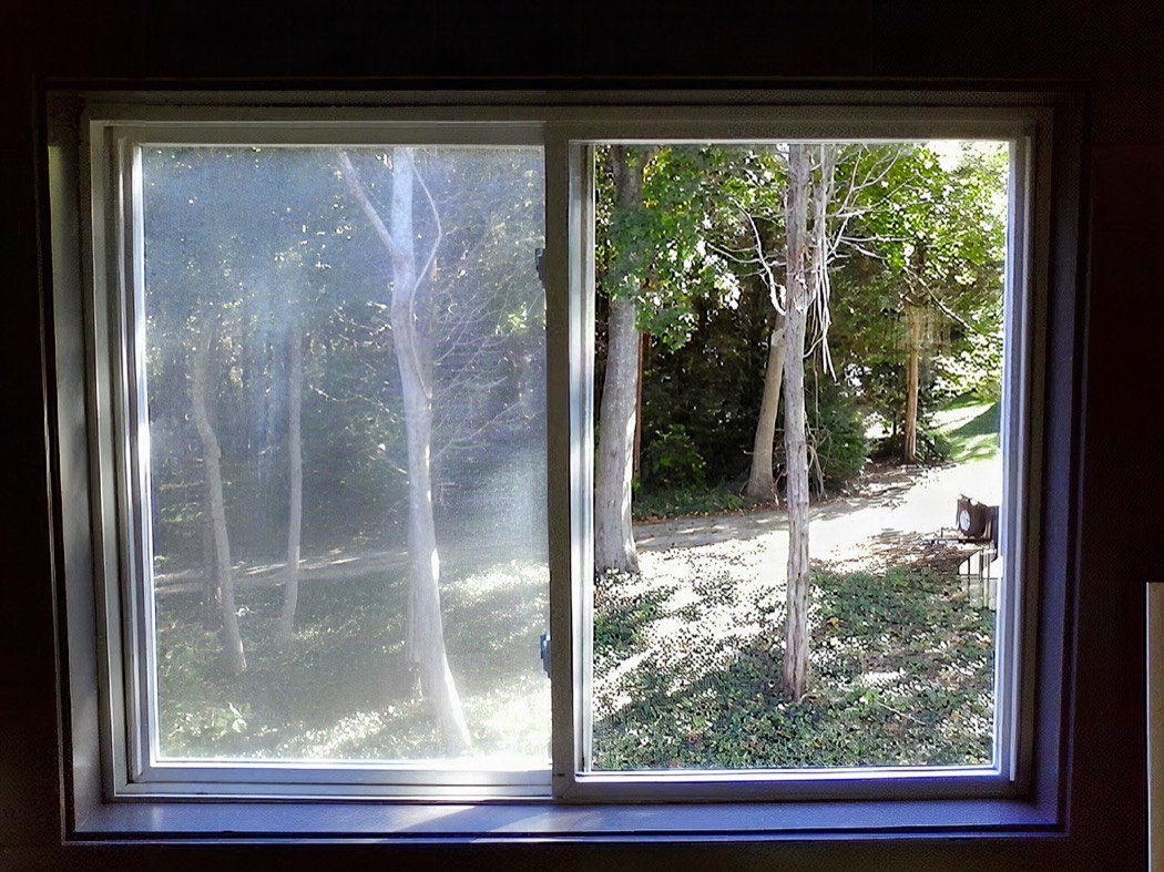 A clean sliding glass door looking out onto a garden