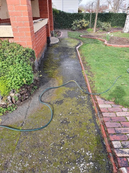 A brick paver path being washed clean beside a Ballarat home