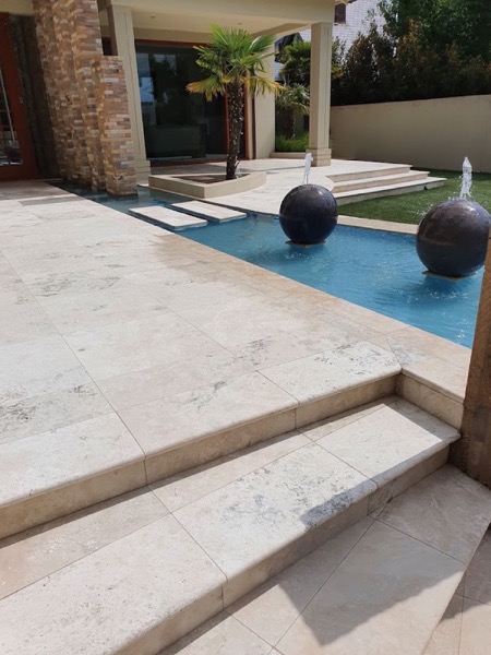 A travertine pool surround and water feature at a Ballarat home