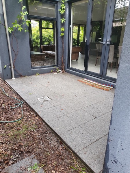 Aggregate concrete paving in front of glass doors