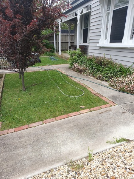 A weatherboard home with a freshly cleaned path and driveway